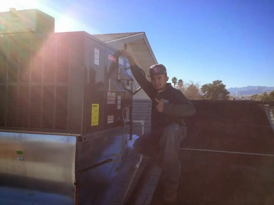 HVAC technician performing Boiler Repair on a rooftop unit in Pine Ridge